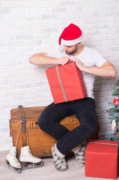 Man i santa hatt öppna rutan och titt på skridskor — Stockfoto