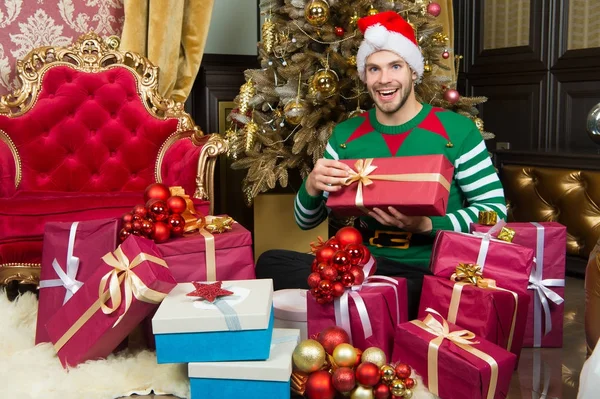 Macho em traje de elfo preparar caixas de presente — Fotografia de Stock