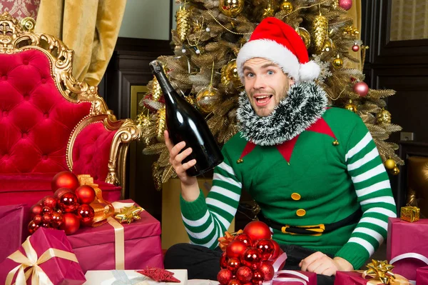 Homem em Papai Noel sorriso com garrafa de champanhe — Fotografia de Stock
