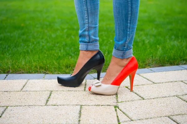 Legs in shoes and jeans on green grass background — Stock Photo, Image