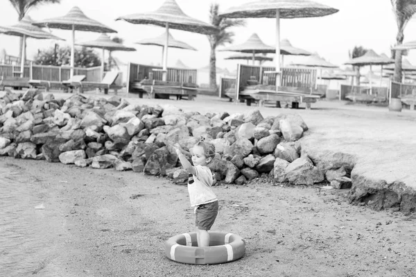 Маленький мальчик с очаровательным лицом с поясом на пляже — стоковое фото