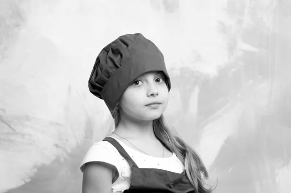 Liten flicka kock med bedårande ansikte i hatt och förkläde — Stockfoto