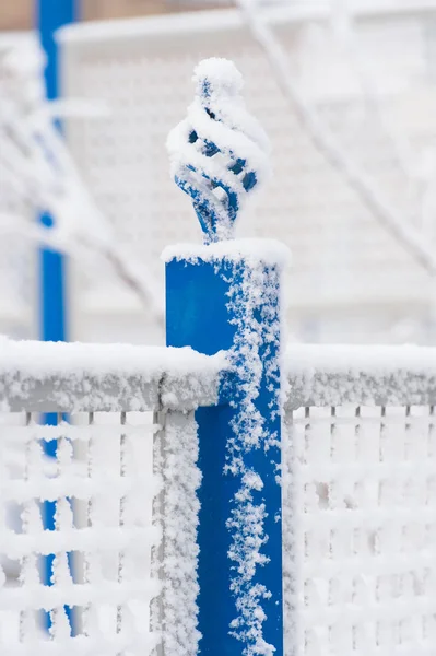 Забор покрыт белым снегом на зимнем фоне — стоковое фото