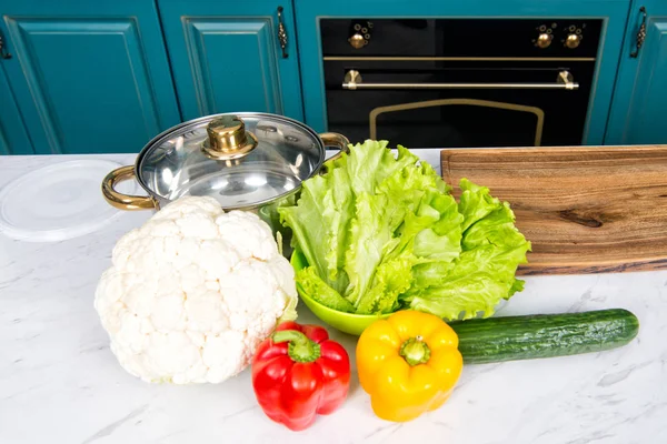 Соус і цвітна капуста, перець, огірок, листя салату на кухонному столі — стокове фото