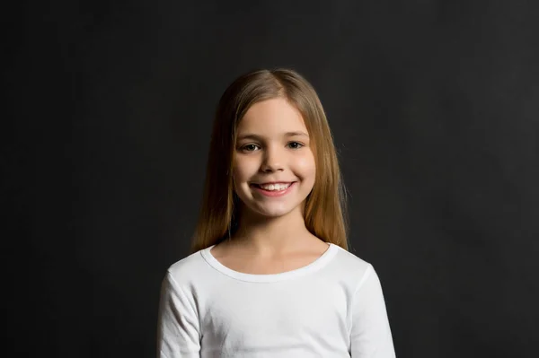 Детская модель улыбается с длинными здоровыми волосами — стоковое фото