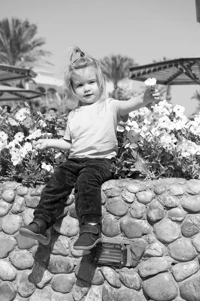 Niño pequeño con cara adorable con flores —  Fotos de Stock