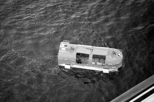 オレンジ色の救助の人々 と緊急避難用の救命ボート — ストック写真