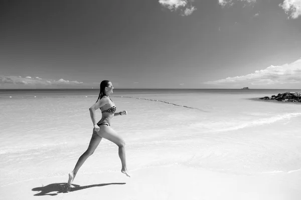 Giovane donna che corre sulla spiaggia tropicale — Foto Stock