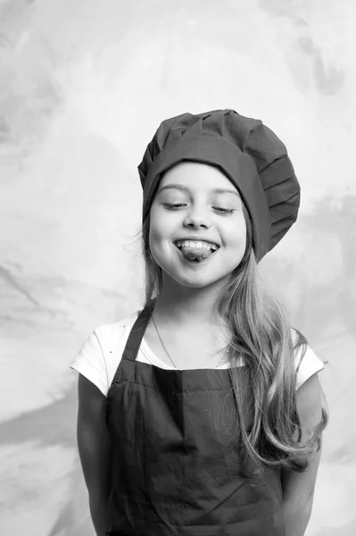 작은 여자 요리사 모자와 앞치마에 행복 한 얼굴로 — 스톡 사진