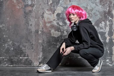 Pembe peruklu saçlar takan bir kadın. Kulaklıklı, klasik filtreli.