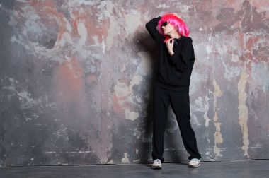 Pembe peruklu kadın. Spor takım elbise giyiyor.