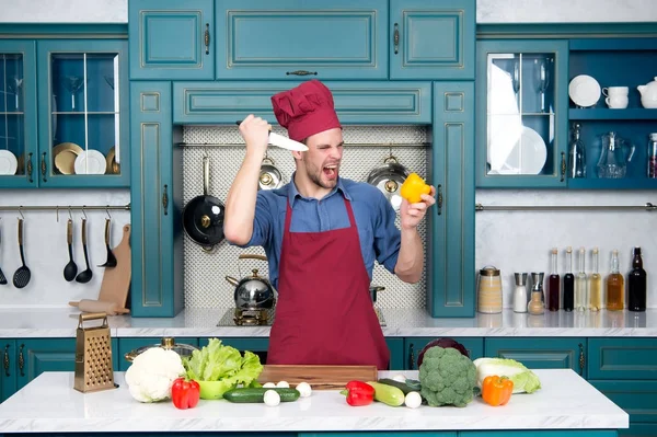 Homem chef com cara zangada com faca cortar pimenta — Fotografia de Stock