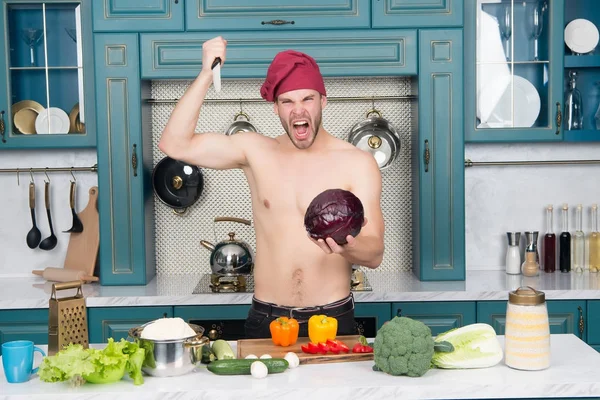 Angry man chef with sexy torso stab knife at cabbage — Stock Photo, Image