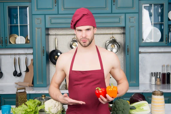 Macho v kuchař klobouk, zástěra bod ruku na pepř — Stock fotografie