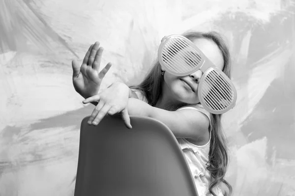 Happy child sitting on orange chair in summer glasses — Stock Photo, Image