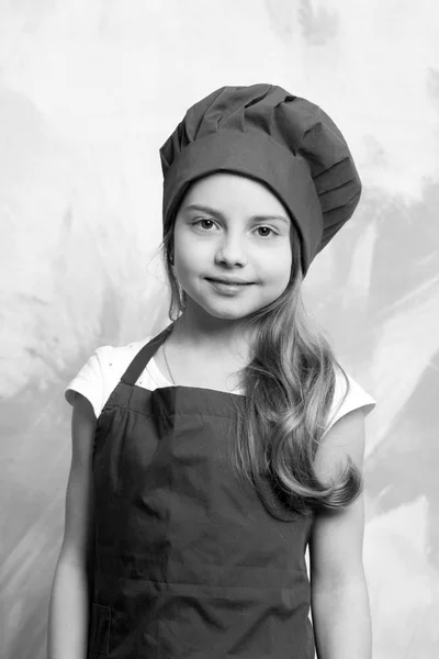 Liten flicka kock med glada ansikte i hatt och förkläde — Stockfoto