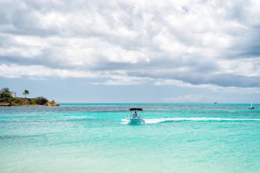 Antigua, Caribbean - 05 Mart 2016: Motorlu tekne bulutlu gökyüzü üzerinde Karayip Denizi'nde. Yaz tatil kavramı. Seyahat, seyahat, Yolculuk tutkusu