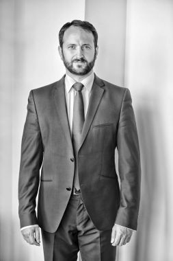 İşadamı veya Yöneticisi poz duvara. Resmi kıyafetli sakallı adam. İş, Girişimcilik kavramı. Moda, Stil, kıyafet. Kariyer, Meslek, iş, siyah ve beyaz