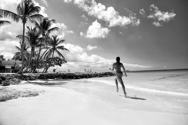在热带海滩 穿着泳衣的年轻貌美的女人在大海中奔跑阳光灿烂的日子 健康的理念 — 图库照片