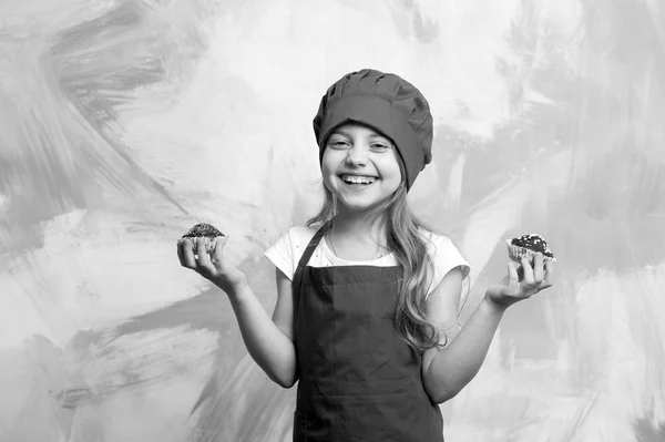 赤シェフの帽子とエプロン カラフルな抽象的な背景 料理や食品にカップケーキを食べる子供か幸せな少女クック — ストック写真