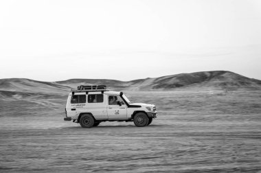 Hurghada, Mısır - 26 Şubat 2017: Araba, cip ya da offroad 4 x 4 araç beyaz gökyüzü arka plan üzerinde çölde sürüş. Safari turu. Aşırı aktivite. Tatil ve seyahat. Yolculuk tutkusu