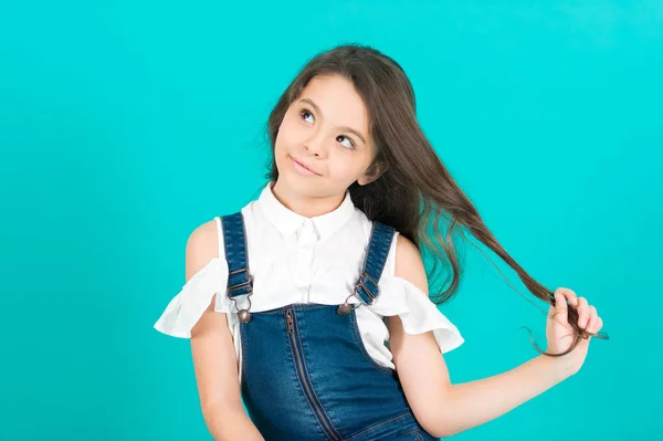 Menina criança com pensamento rosto segurar longo cabelo morena — Fotografia de Stock