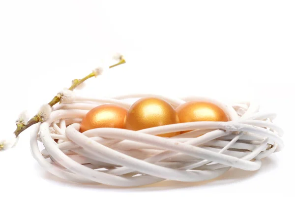 Традиционные яйца, окрашенные в золотой цвет внутри тканого деревянного венка — стоковое фото