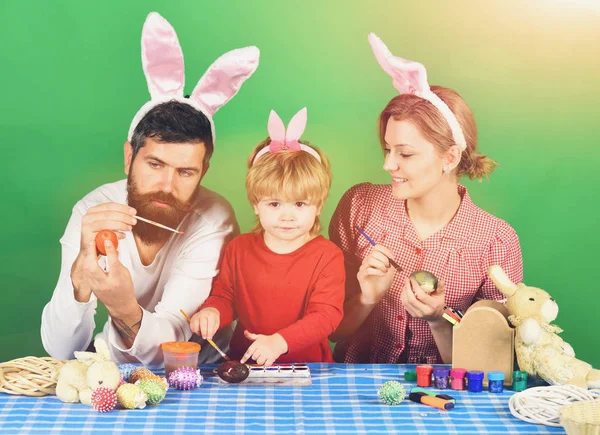 Мати, батько і дочка малюють яйця в рожевих вухах кролика — стокове фото