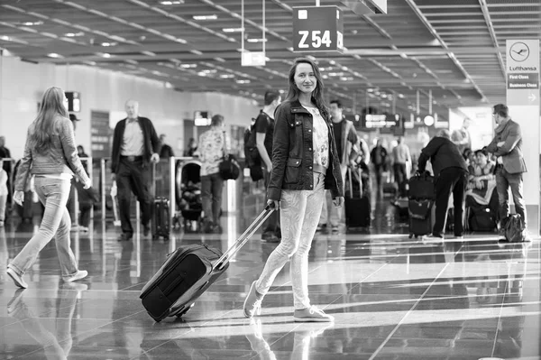 Woman standing with black travel bag in airport, Germany — Stock Photo, Image