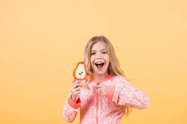 Κορίτσι δάχτυλο στο γλειφιτζούρι σε πορτοκαλί φόντο — Φωτογραφία Αρχείου