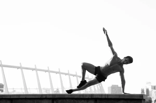 Deportista haciendo balance de brazo en el techo —  Fotos de Stock