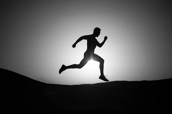 Correndo silhueta homem no céu por do sol — Fotografia de Stock