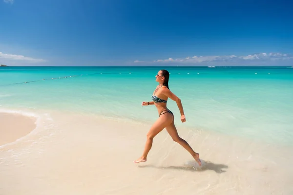 Mujer en bikini correr en la playa en la antigua — Foto de Stock