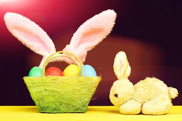 Jouet Lapin de Pâques et panier plein d'œufs de Pâques colorés — Photo