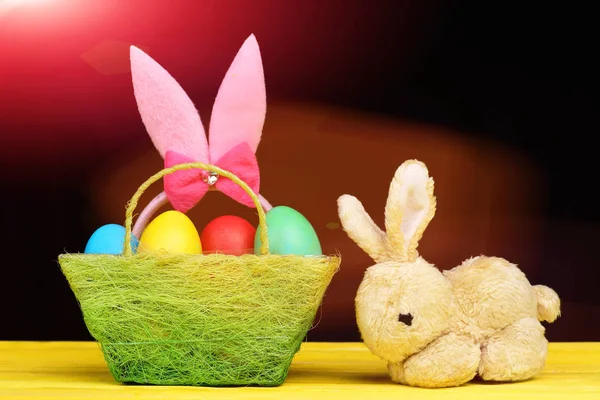 Zabawka króliczek na żółtym drewnianym stole przez Wielkanoc wystrój — Zdjęcie stockowe