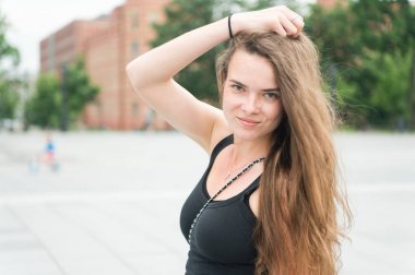 Uzun saçlı kadın şehirli arka planda poz veriyor, güzellik