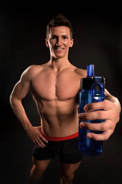 Sportsman con bottiglia sportiva su sfondo scuro — Foto Stock