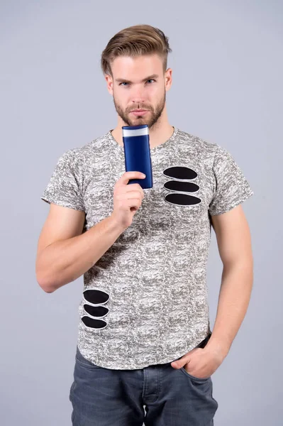 Hombre con gel o botella de champú en la mano — Foto de Stock