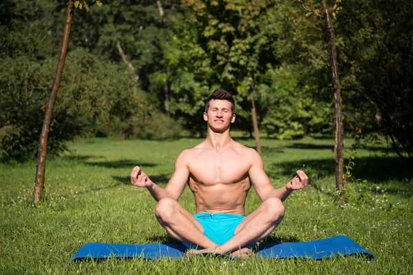 Mannen med frisk kropp meditera på yogamatta — Stockfoto