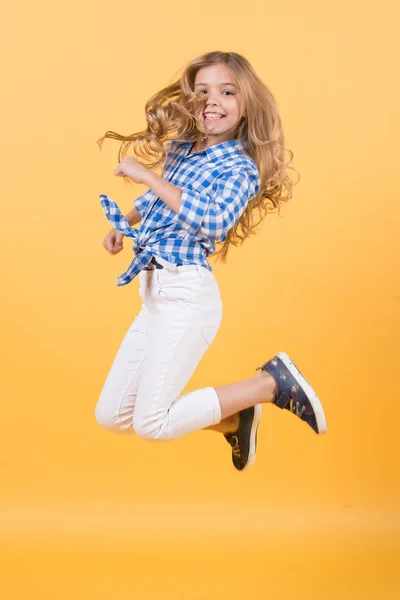 Niño salto sonriendo sobre fondo naranja — Foto de Stock