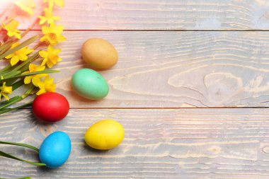 ahşap üzerine sarı nergis ile renkli Paskalya yumurtaları