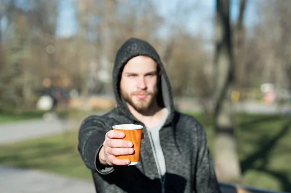 Café ou xícara de chá na mão de homem desfocado no parque — Fotografia de Stock