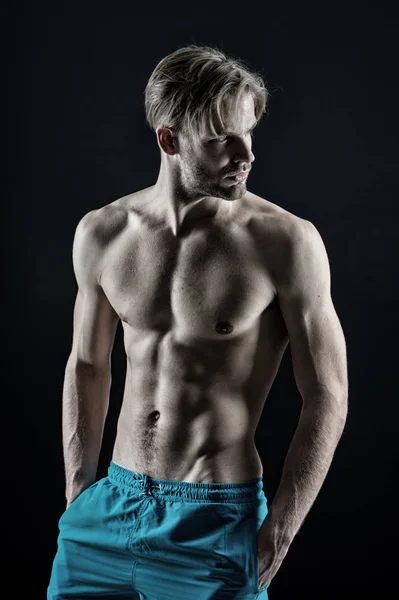 Macho zeigt muskulösen Oberkörper in blauen Shorts — Stockfoto