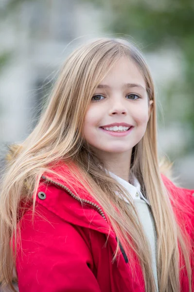 Niño con el pelo largo rubio sonrisa al aire libre — Foto de Stock