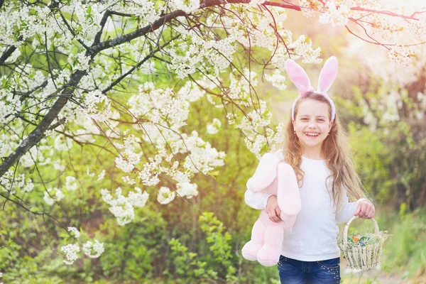 Glad barn promenader i trädgården med blommande träd — Stockfoto