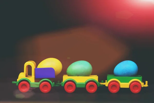 Traditional eggs in plastic colorful car toy or locomotive — Stock Photo, Image
