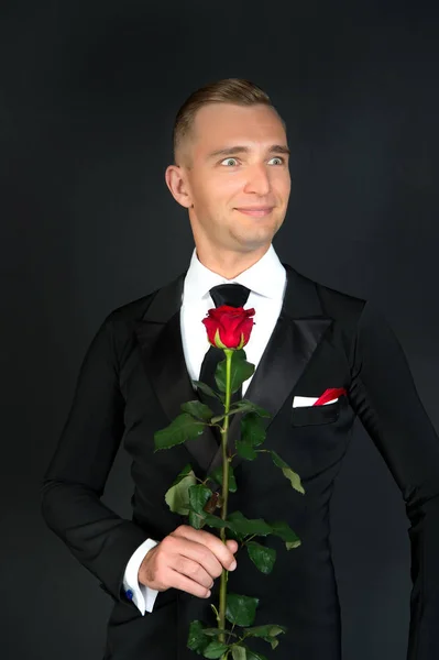 舞厅舞蹈家微笑与红色玫瑰色在黑暗的背景 — 图库照片