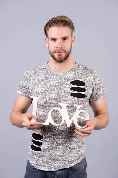 Hombre con cara seria sostener palabra de amor de madera, diseño — Foto de Stock