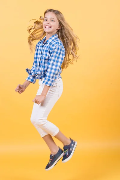 Mädchen springen lächelnd auf orangefarbenem Hintergrund — Stockfoto