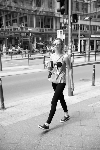 Κορίτσι σε μοντέρνα ρούχα και γυαλιά ηλίου, περπατώντας στο πεζοδρόμιο — Φωτογραφία Αρχείου